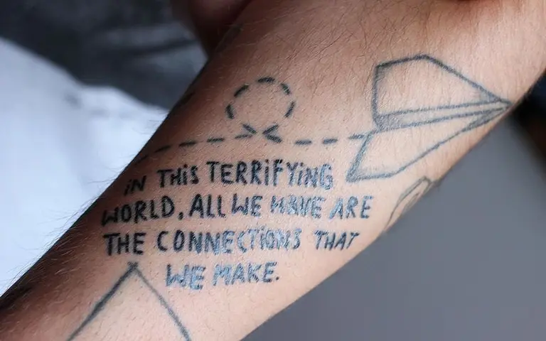 Auf einem Unterarmtattoo steht: 