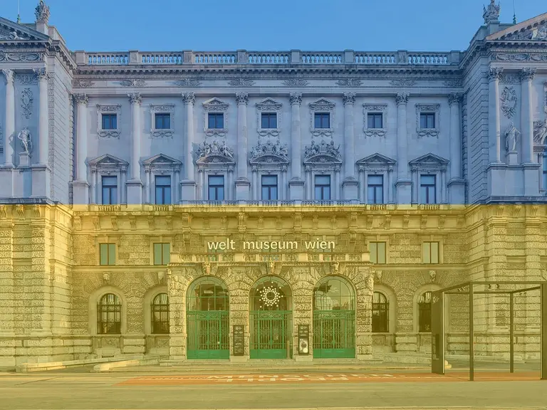 Das Bild zeigt die Fassade des Weltmuseums Wien. Die Architektur ist historisch, mit kunstvollen Verzierungen und großen Fenstern. Der Eingangsbereich ist grün gefärbt und trägt den Schriftzug 