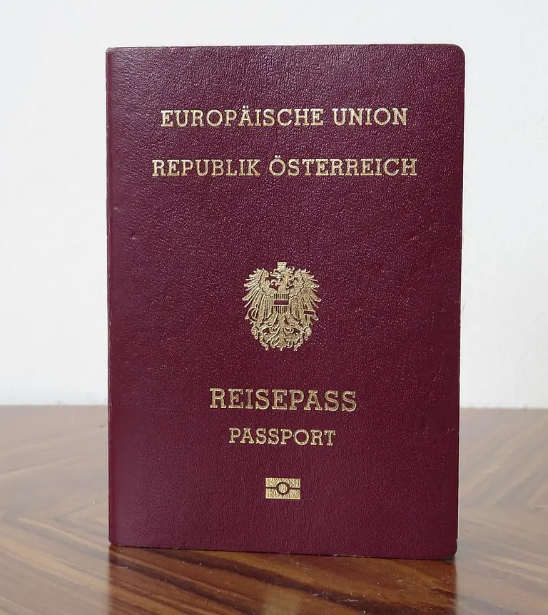 Ein österreichischer Reisepass in dunkelrot mit goldener Schrift. Auf der Vorderseite steht „Europäische Union“, „Republik Österreich“ sowie „Reisepass“ und „Pass“ in zwei Sprachen. Das österreichische Wappen ist ebenfalls abgebildet.