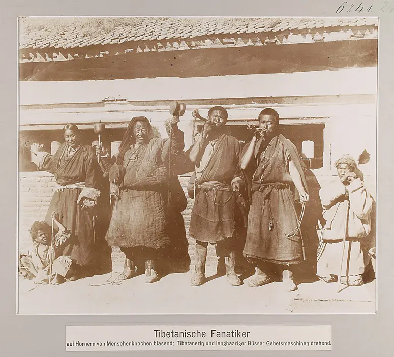 Tibetanische Fanatiker auf Hörnern von Menschenknochen blasend; Tibetanerin und langhaariger Büsser Gebetsmaschinen drehend