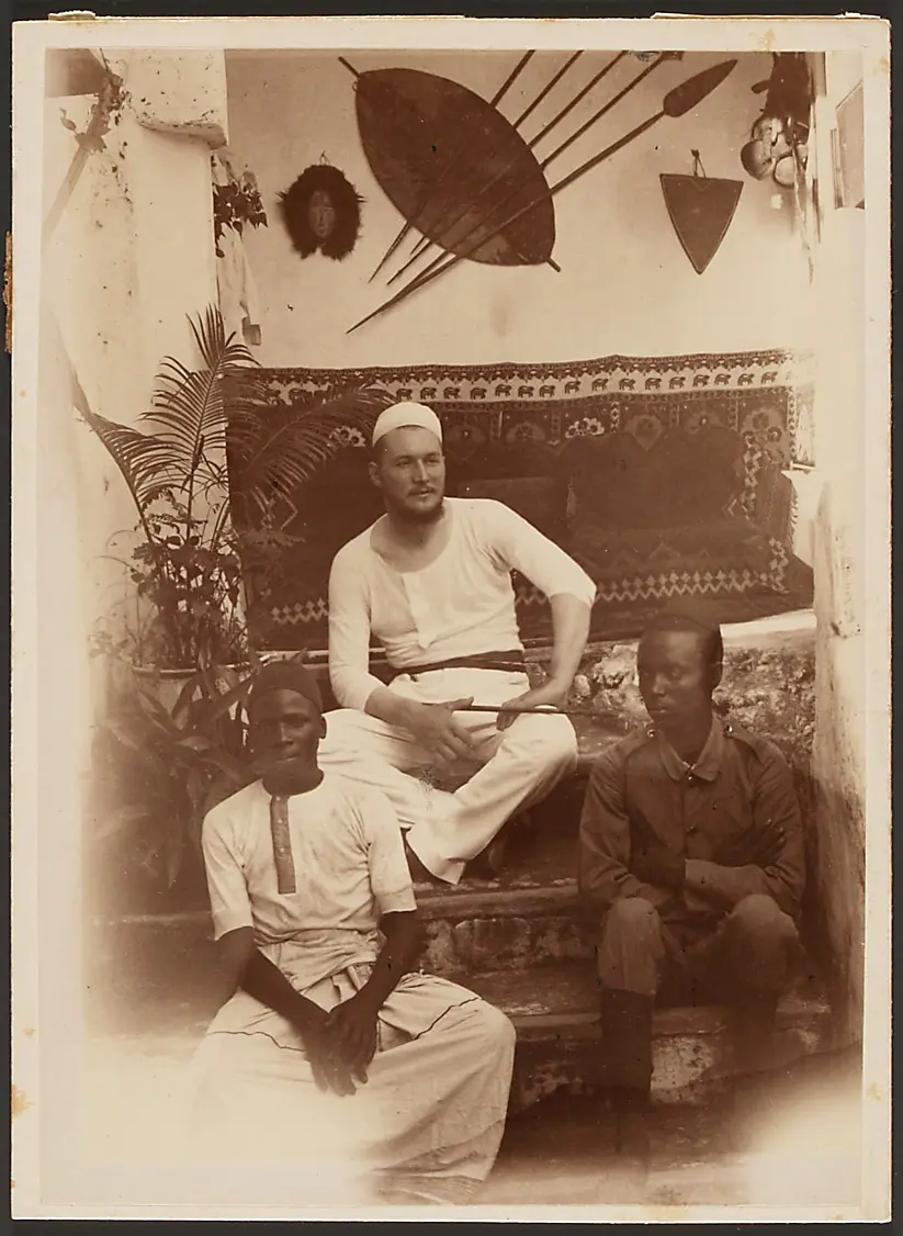 Oscar Baumann with two Africans inside a house
