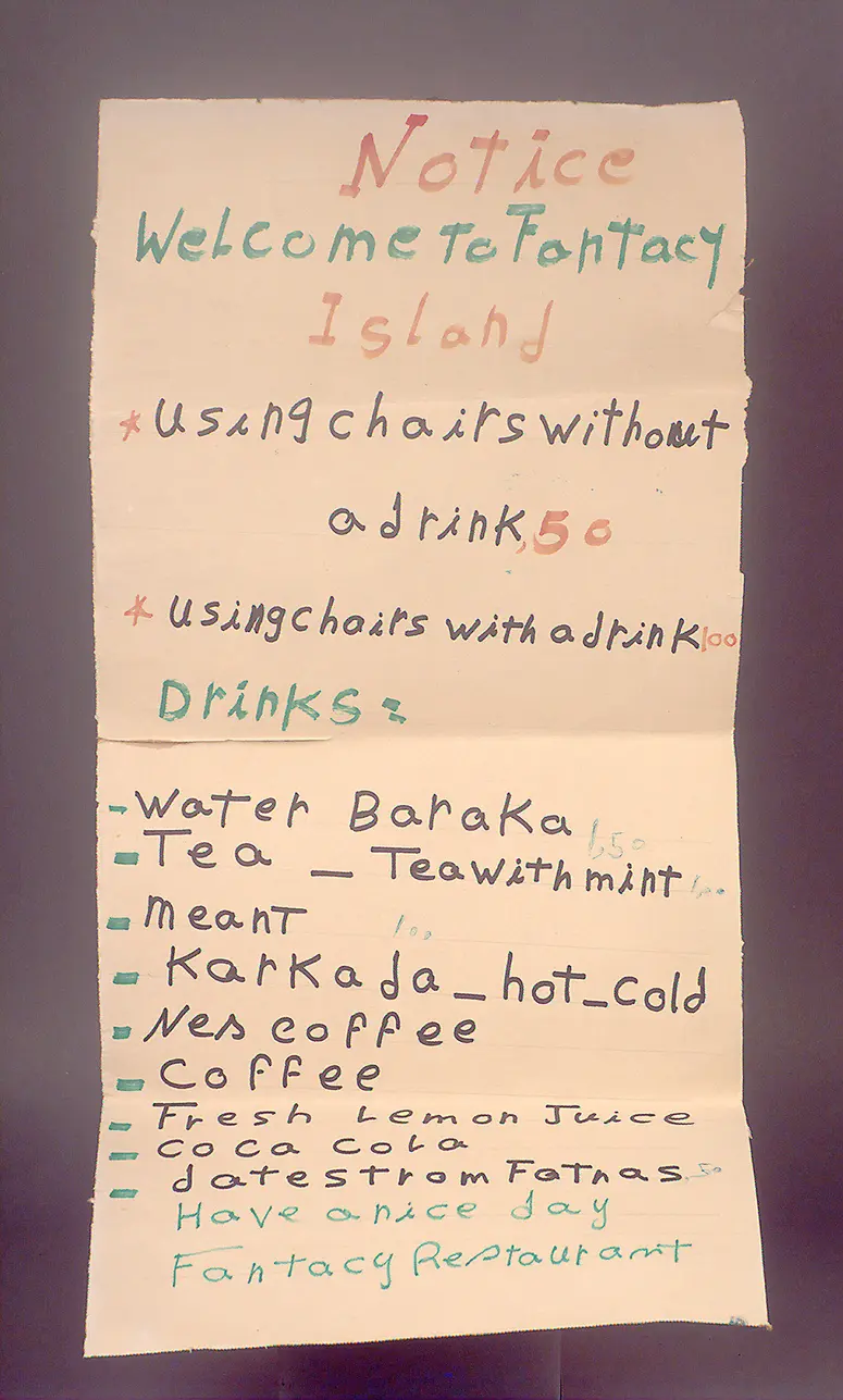 Beschriebener Karton, rechteckige Aufschrift: 'Notice. Welcome to Fantacy Island. Using chairs...'