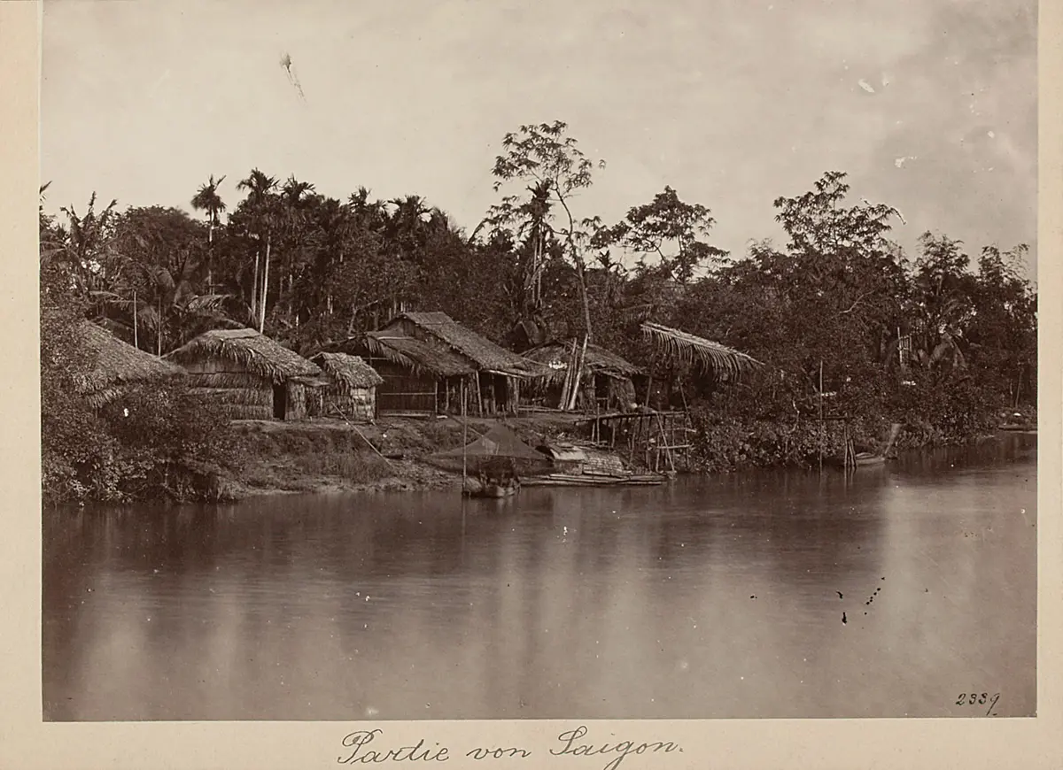Strohgedeckte Hütten an einem Gewässer bei Saigon