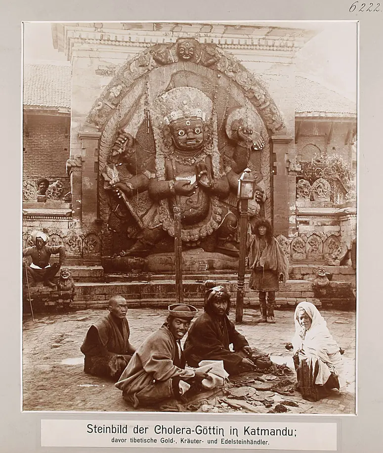 Steinbild der Cholera-Göttin in Katmandu; davor tibetische Gold-, Kräuter- und Edelsteinhändler